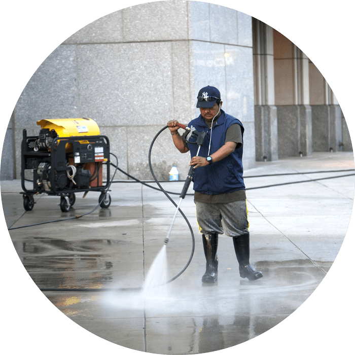 Worker with a pressure washing machine cleaning a floor